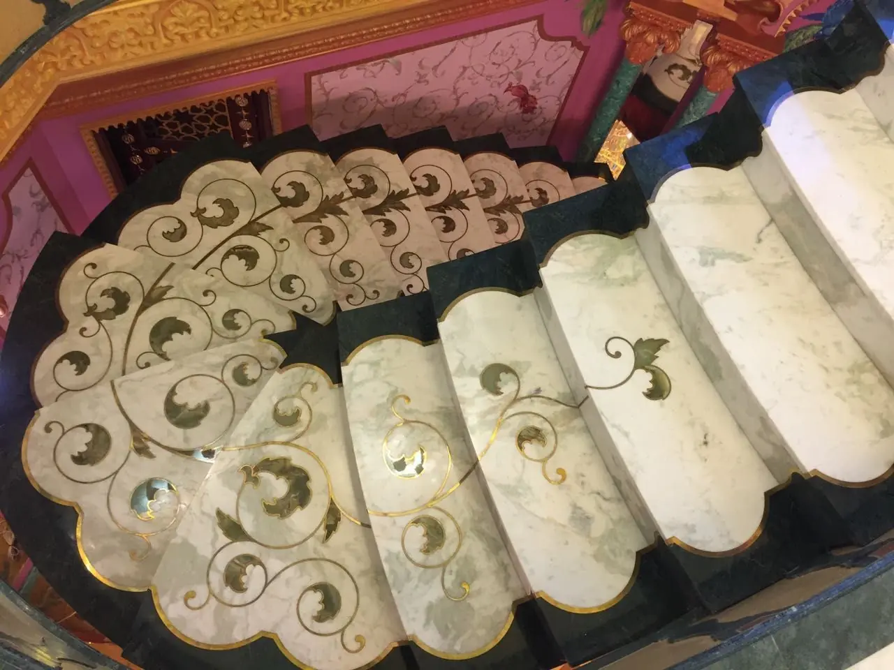 Peldaños de mármol blanco con incrustaciones florales en piedra de color